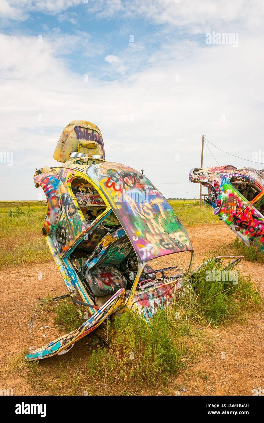 painted Volkswagen Beetles half buried at an angle at Slug Bug Ranch
