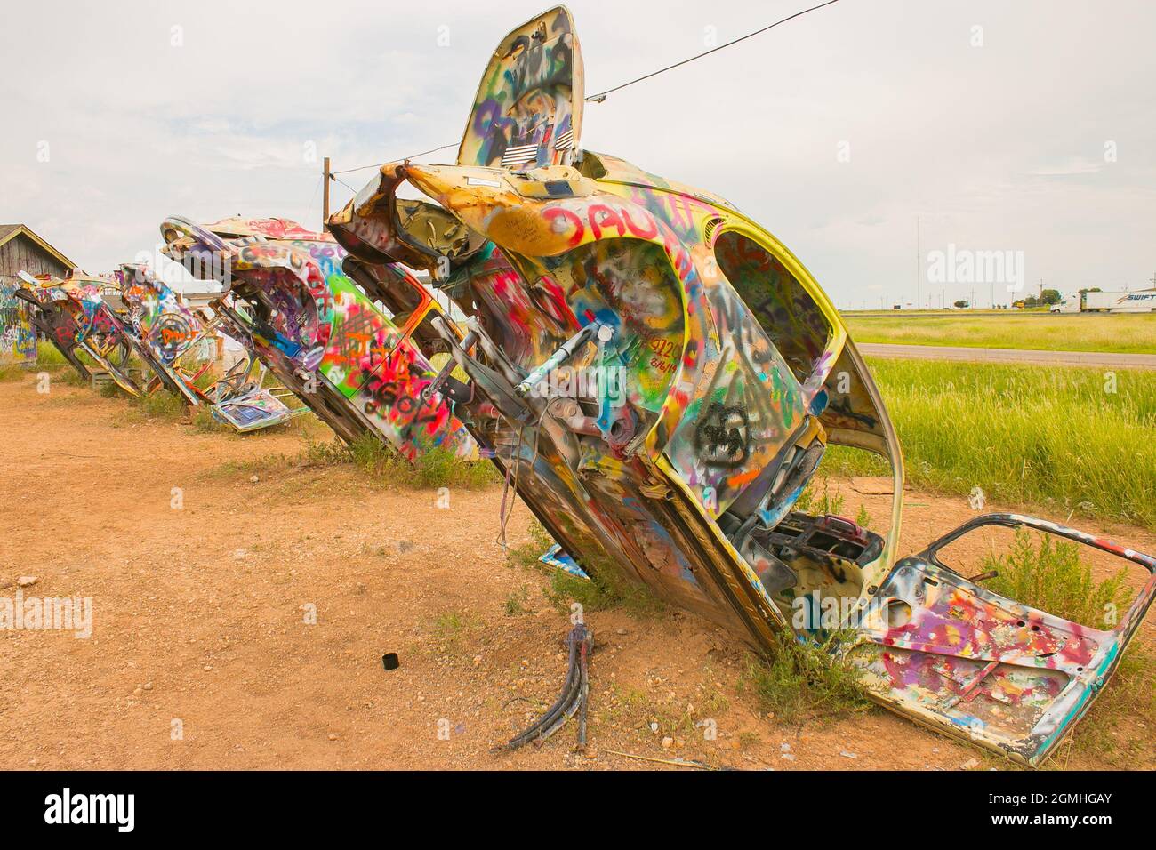 painted Volkswagen Beetles half buried at an angle at Slug Bug Ranch