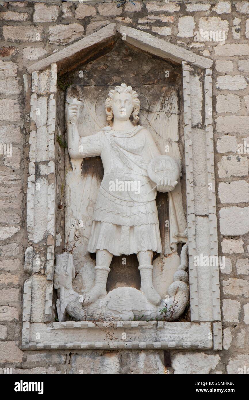 Sibenik, Croatia - August 25, 2021: Stone sculpture of Saint Michael the Archangel killing a dragon, detail on stone and glass public library building Stock Photo