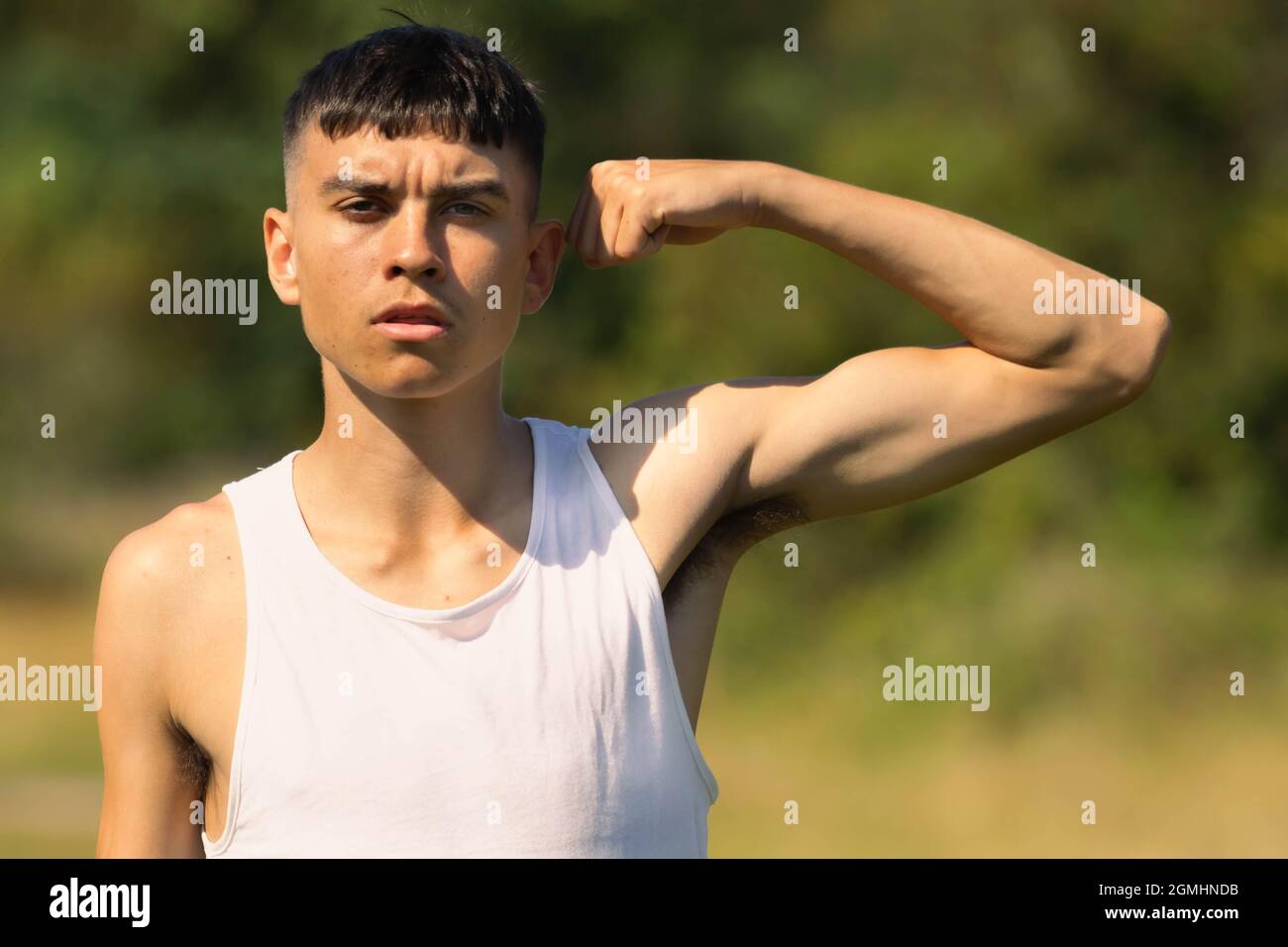 An 18 year old teen boy in a sleeveless top on a late summer's day
