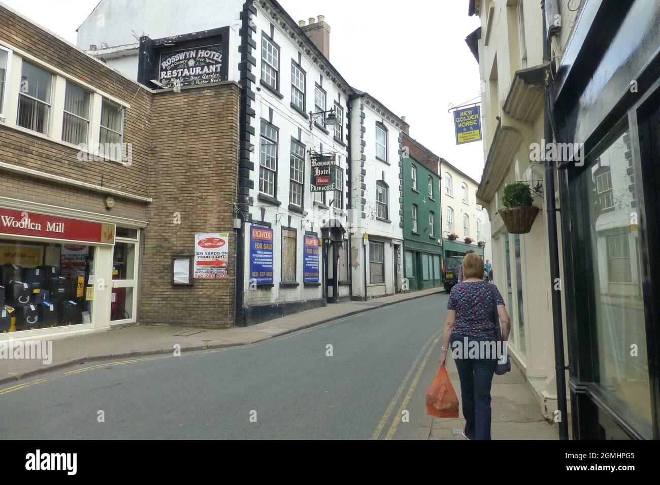 Ross on Wye Restaurant lady carrying shopping in street hanging baskets