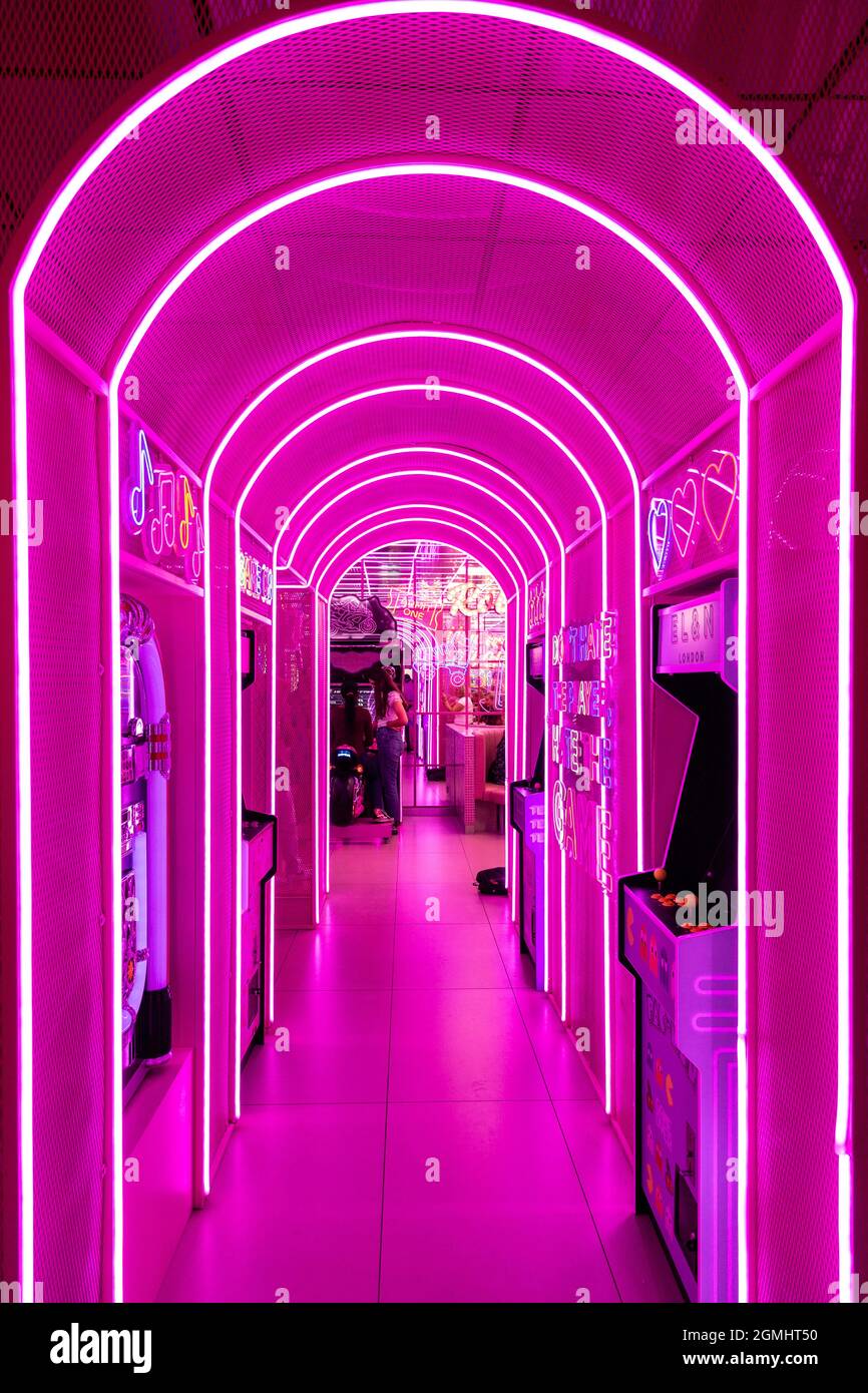 Pink light tunnel with retro arcade games at EL&N Soho cafe, London, UK Stock Photo