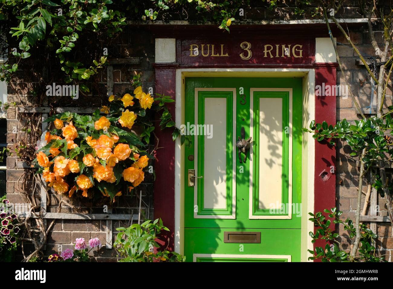 Pretty cottage door and window with flower displays in Much Wenlock