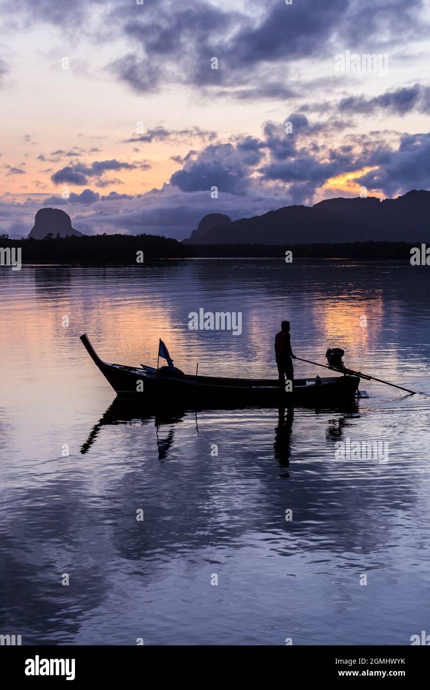 silhouette fisherman in fishing boat on sea at sunrise Stock Photo - Alamy