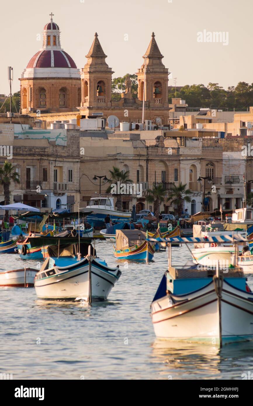 Colorful boats in front of the scenic porttown Marsaxlokk in Malta