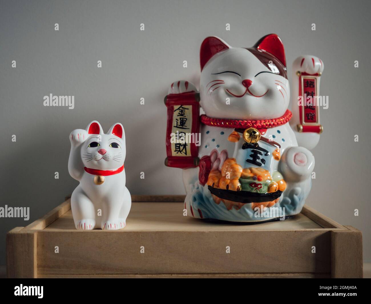 Pair of asian fortune cats on a wooden crate Stock Photo