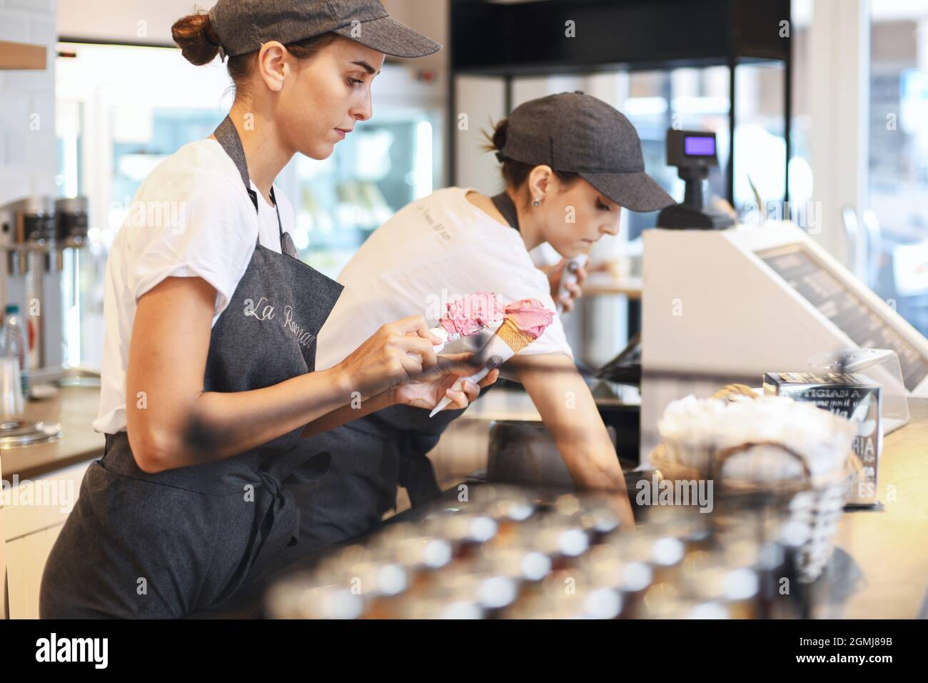 VERONA, ITALY - AUGUST 16, 2019:A girl prepares vanilla ice cream in the famous cafeteria La Romana Stock Photo