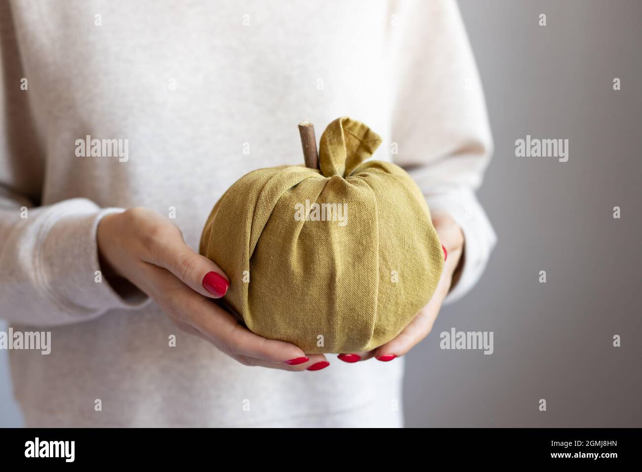 female hands holding fabric pumpkin. Furoshiki gifts Stock Photo