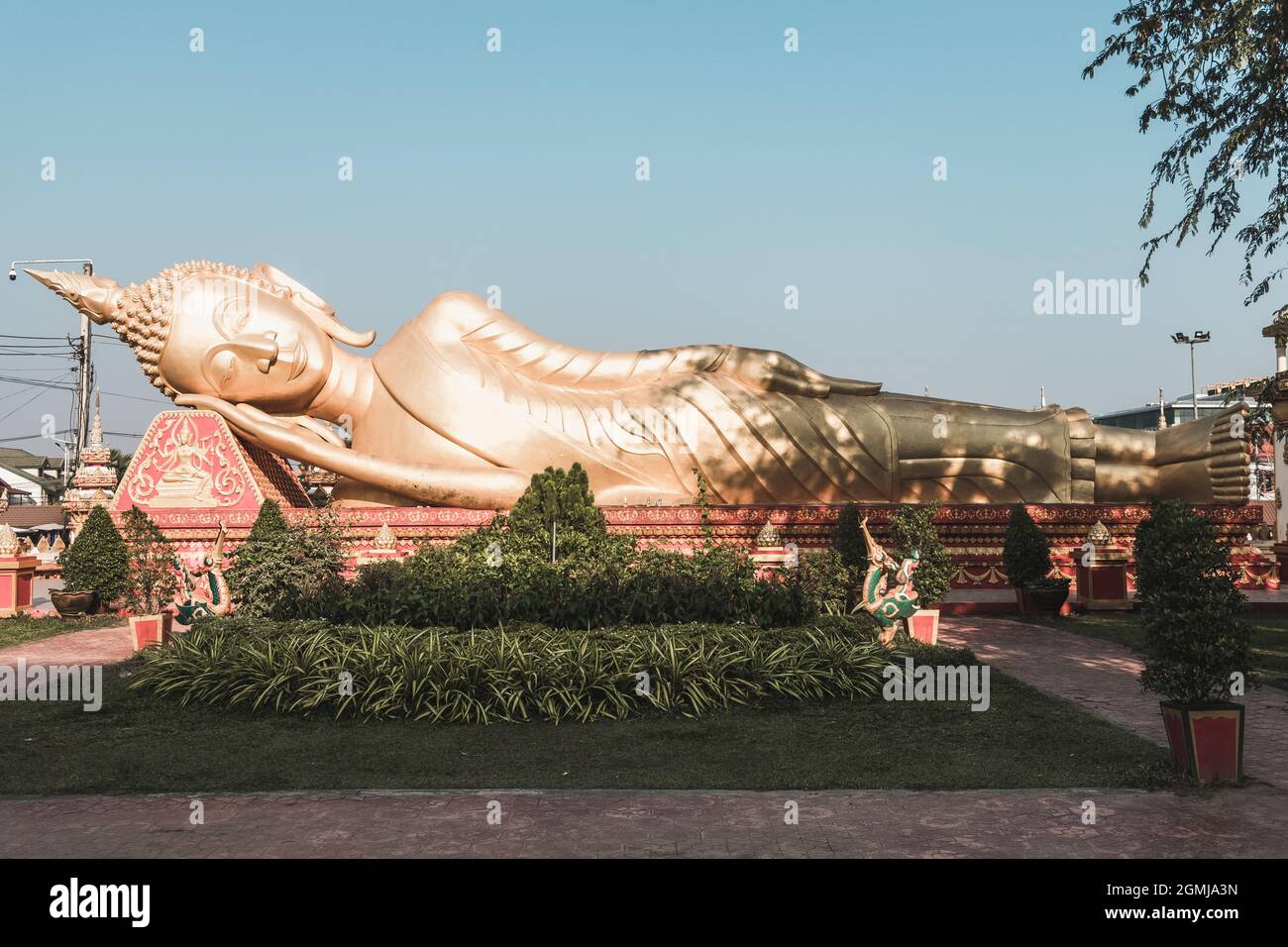 Statue of a large golden reclining Buddha in a park in Vientiane in Laos. High quality photo Stock Photo