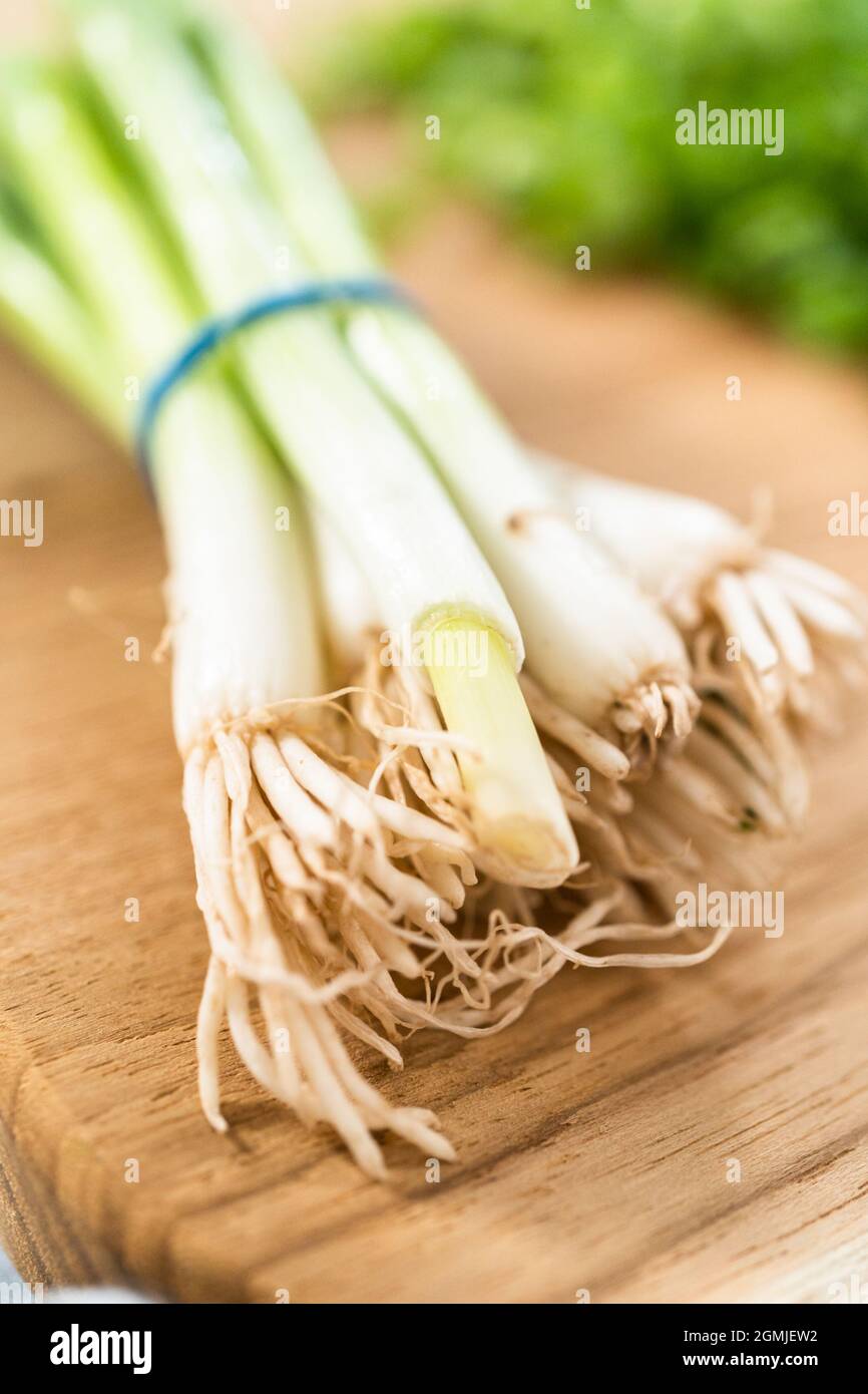 Chopping organic green onions on a wood cutting board Stock Photo - Alamy