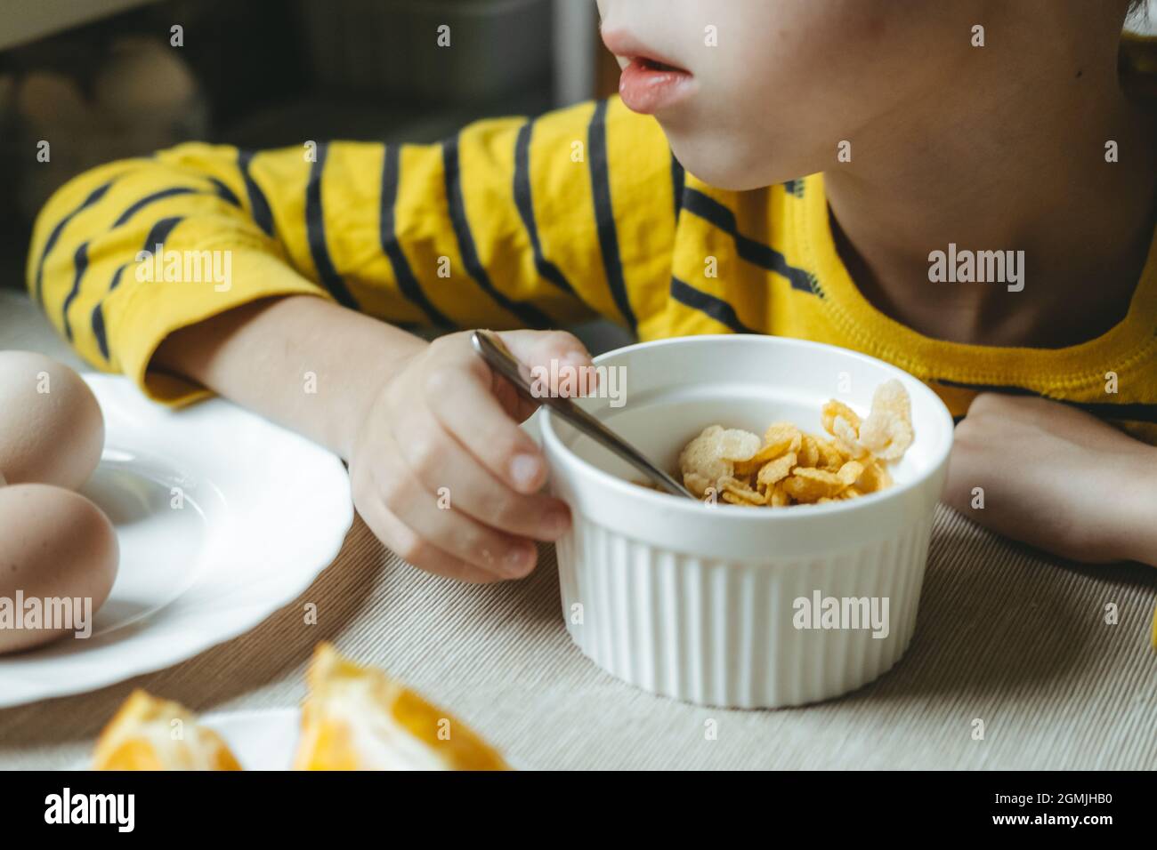 boy eats breakfast in the morning with cereals with milk. flakes close-up Stock Photo
