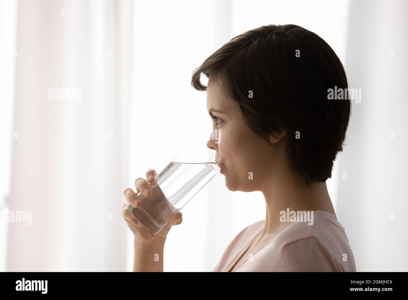 Healthy young female hold glass drink still mineral water Stock Photo