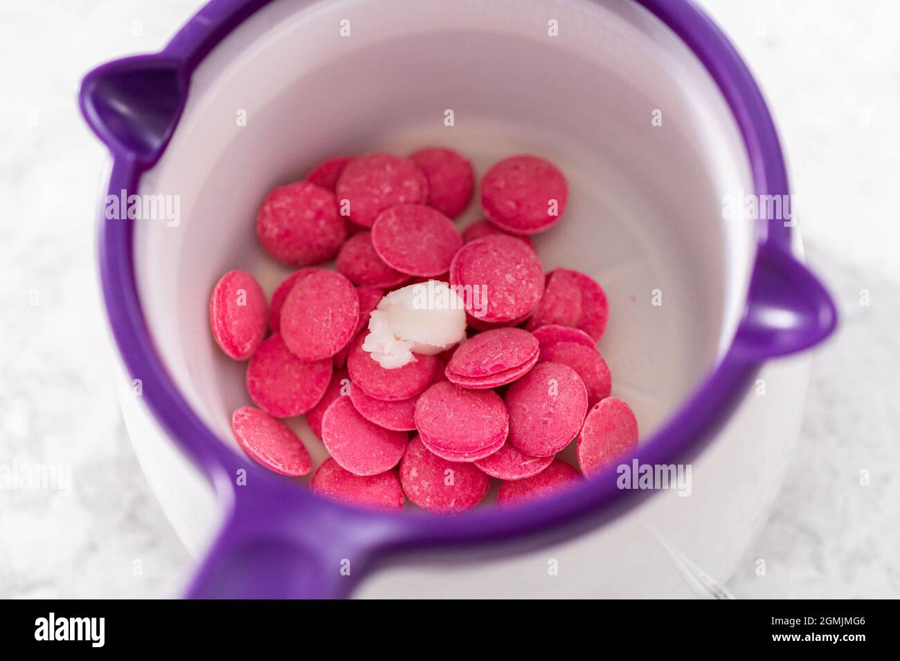 Melting chocolate melts in a candy melting pot to prepare gourmet mini  chocolates with sprinkles Stock Photo - Alamy