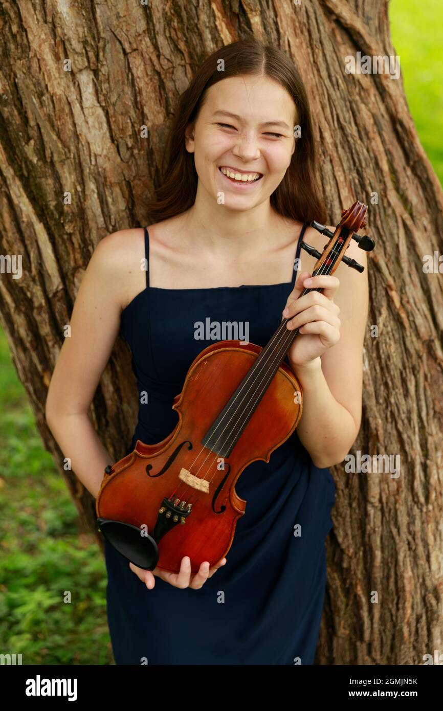 Asian girl in nature with violin. High quality photo Stock Photo - Alamy