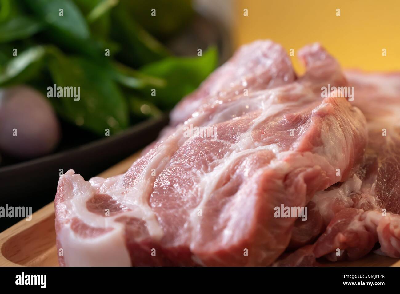 Close up macro shooting sliced pork meat on wood plate in studio light. Stock Photo