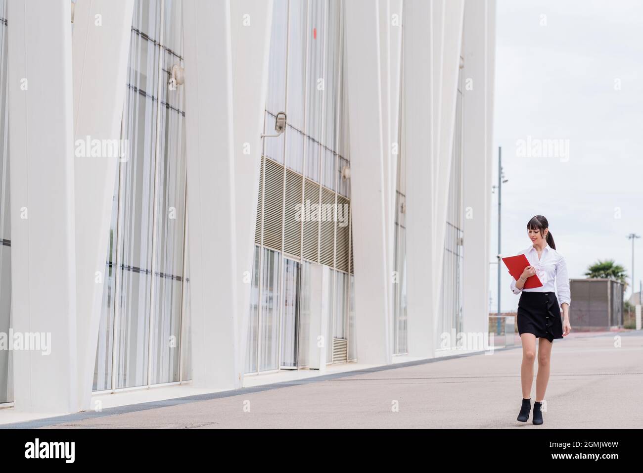 Portrait of beautiful business woman holding notebook on her way to work Stock Photo