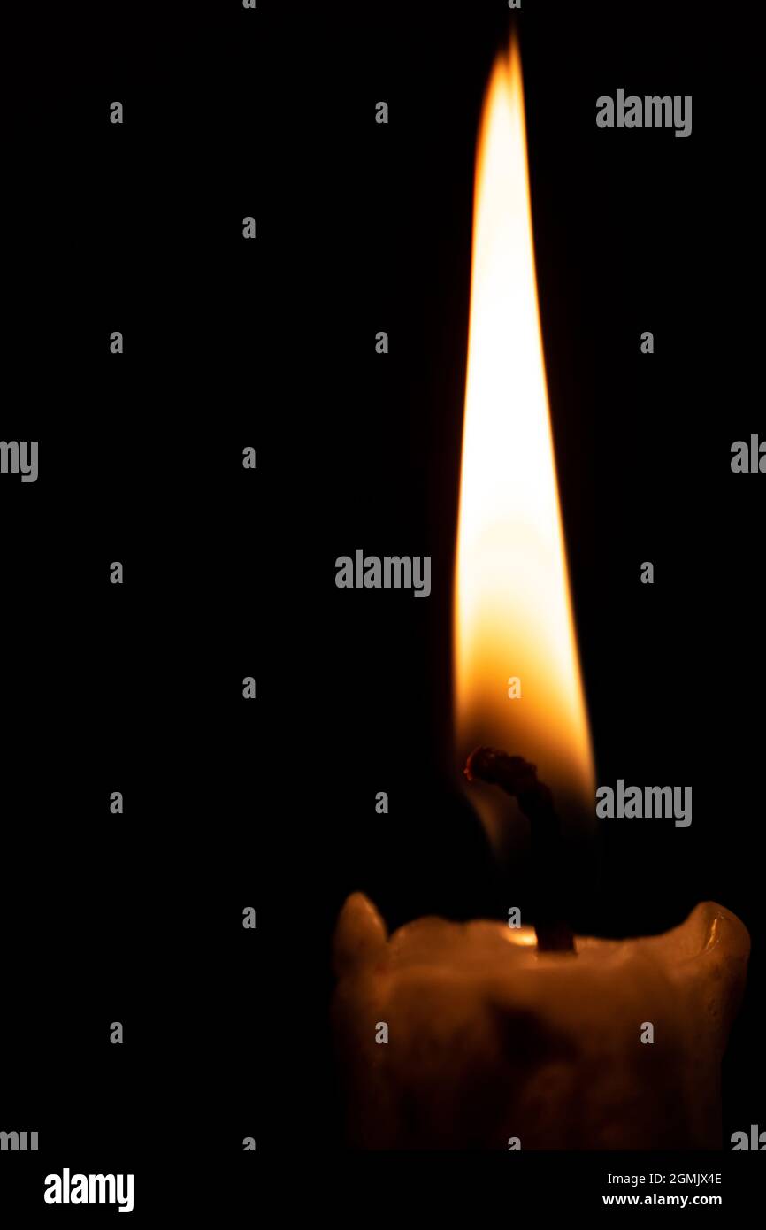 Candle flame in the dark. Fire against a dark background, symbolism of light and darkness Stock