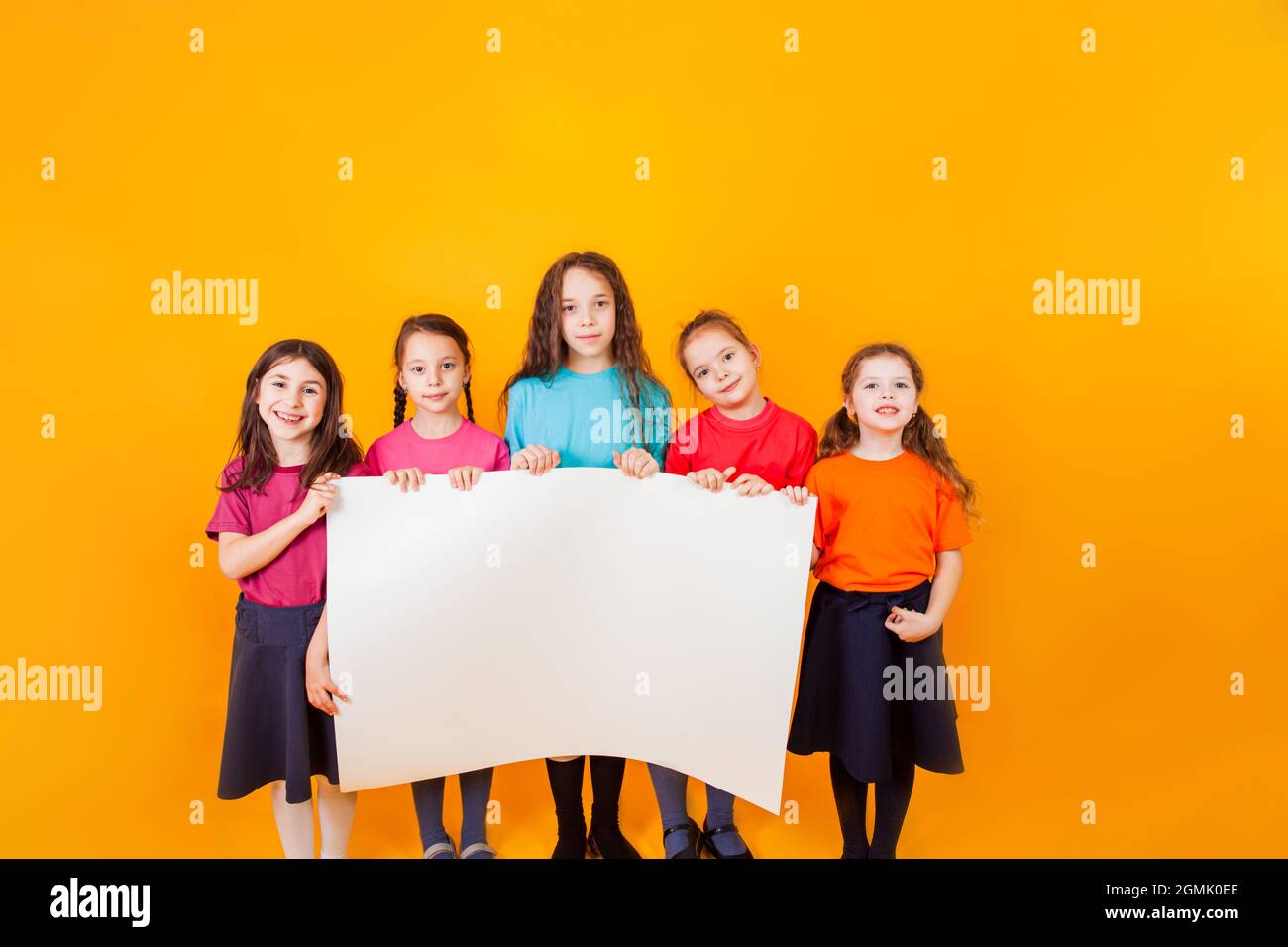 The different little boys are holding a big white paper Stock Photo - Alamy