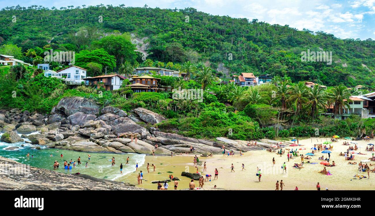 Tourists enjoying the Itacoatiara beach in Niteroi, Rio de Janeiro, Brazil. With a beautiful landscape, this beach is famous for offering the ideal co Stock Photo