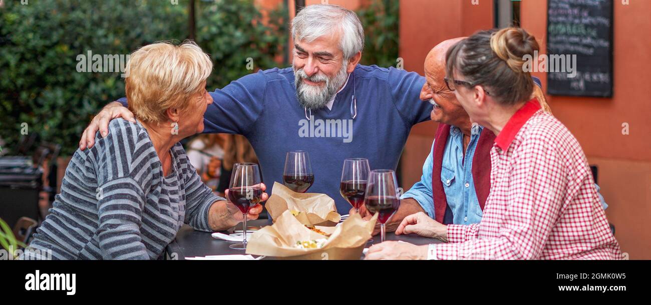 Group of old people eating and drinking outdoor - Senior couples having fun together Stock Photo