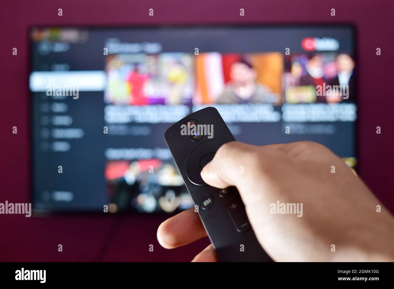 Hand Holding Remote Control and Changing Channel Stock Photo