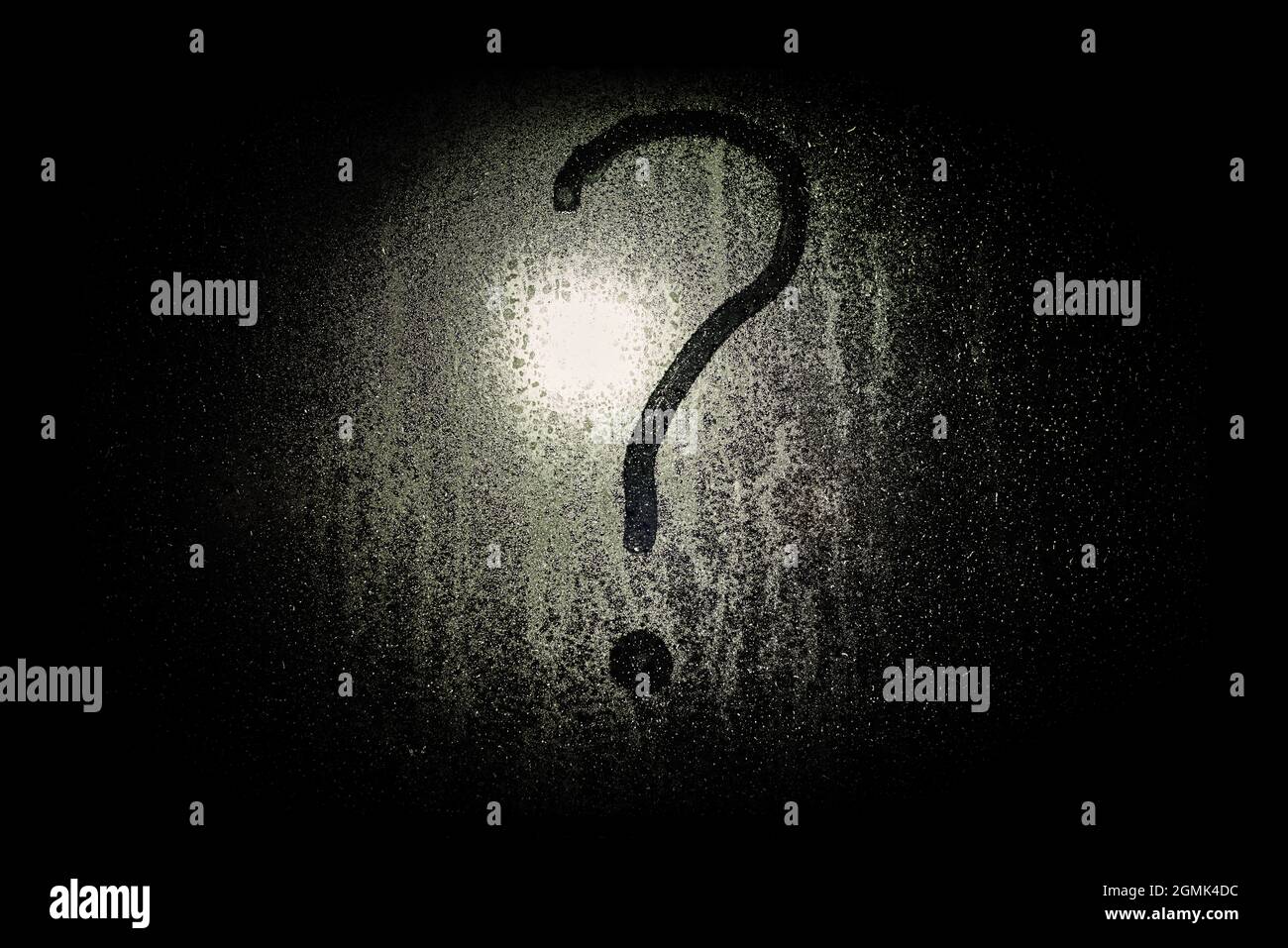 A question mark on rainwet glass. Water drops on the window. Question
