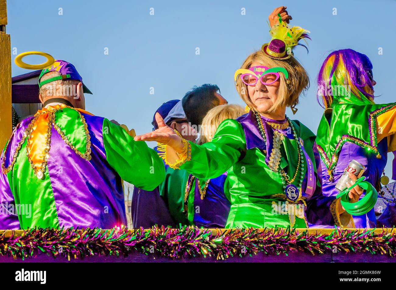 A woman throws a frisbee during the Joe Cain Day Mardi Gras parade, Feb