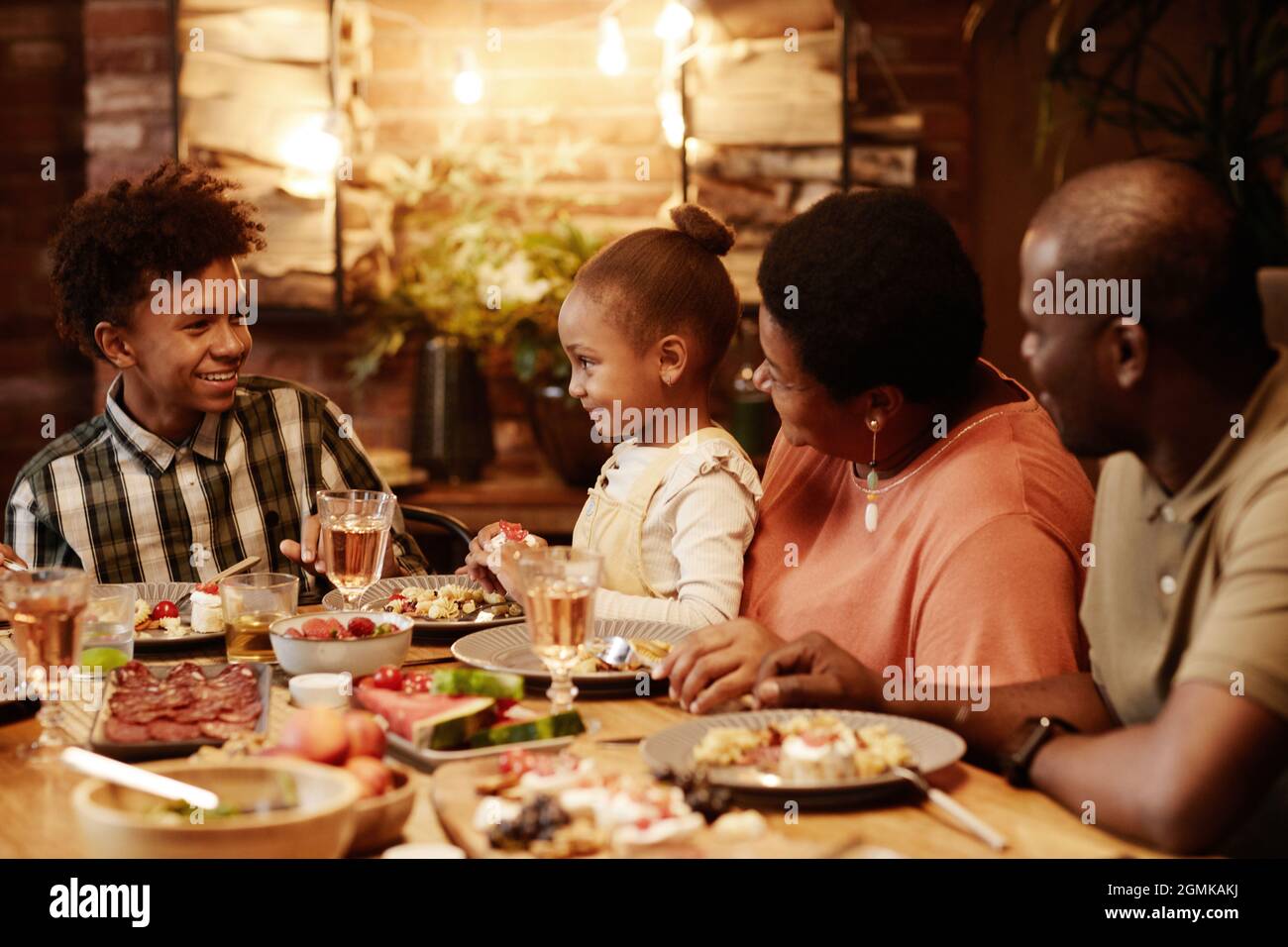 Warm toned portrait of happy African-American family enjoying dinner