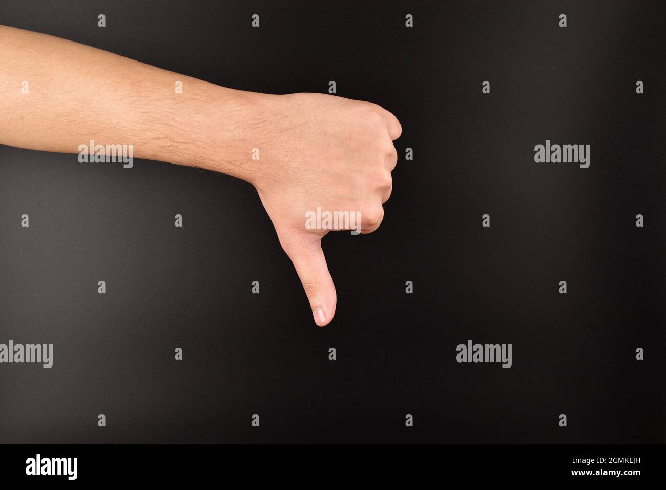 hand showing thumbs down gesture on dark background Stock Photo