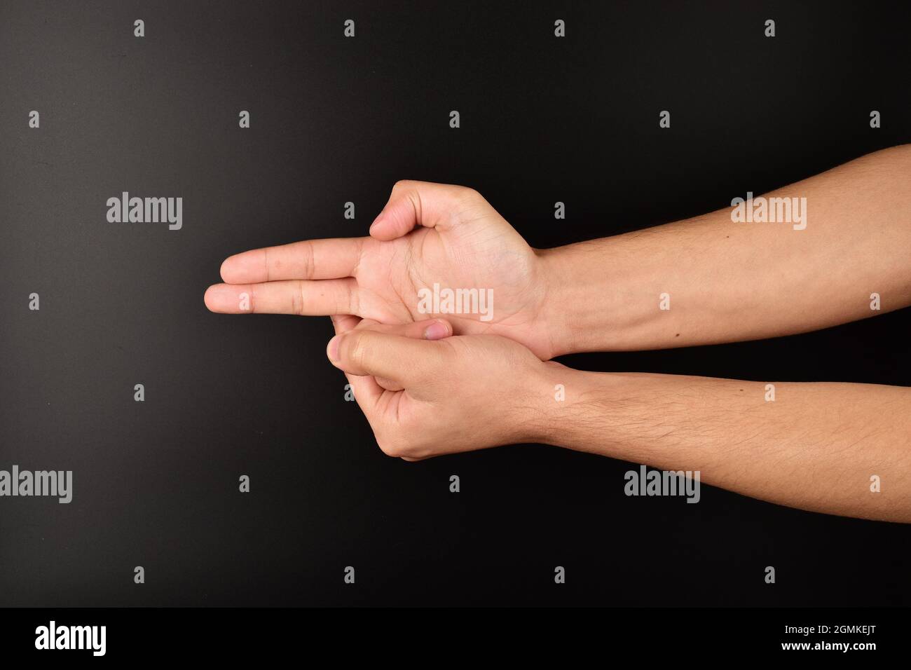man making gun gesture on dark background Stock Photo