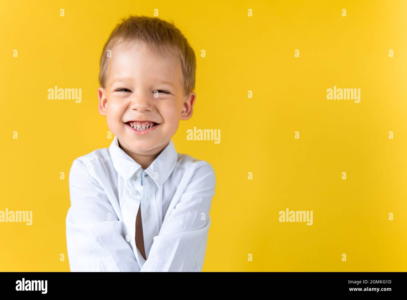 Banner Funny Preschool Child Boy in unbuttoned shirt smile narrow eye on Yellow Background Copy Space. Happy Smiling Kid Go Back to School Stock Photo