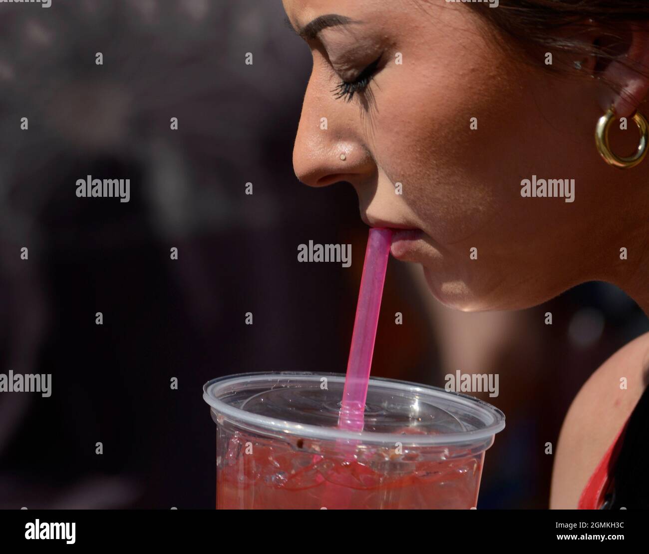 A woman enjoys an ice cold glass of watermelon juice at the annual Fiesta de Santa Fe in Santa Fe, New Mexico. Stock Photo