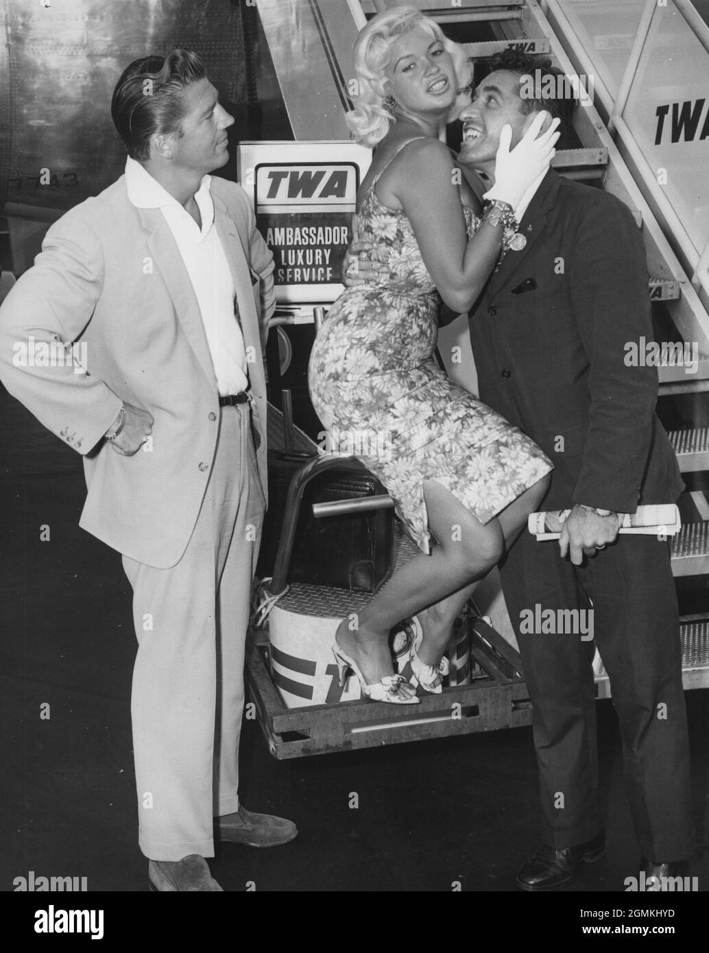1959 - JAYNE MANSFIELD offers her valued acting experience for the benefit of amateur actor PAUL CORRERI while her husband MICKEY HARGITAY looks on following their arrival on a TWA jetliner from Los Angeles. Mansfield is en route to London where she will work on her latest movie, 'Too Hot Too Handle'. Exact date and place unknown.  (Credit Image: © Keystone Press Agency/ZUMA Wire) Stock Photo