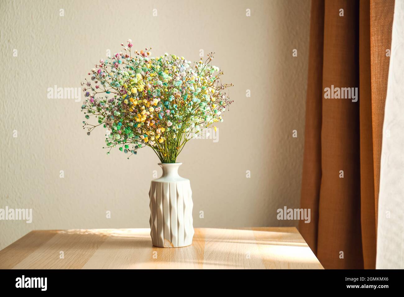 Vase with beautiful gypsophila flowers on table in room Stock Photo - Alamy