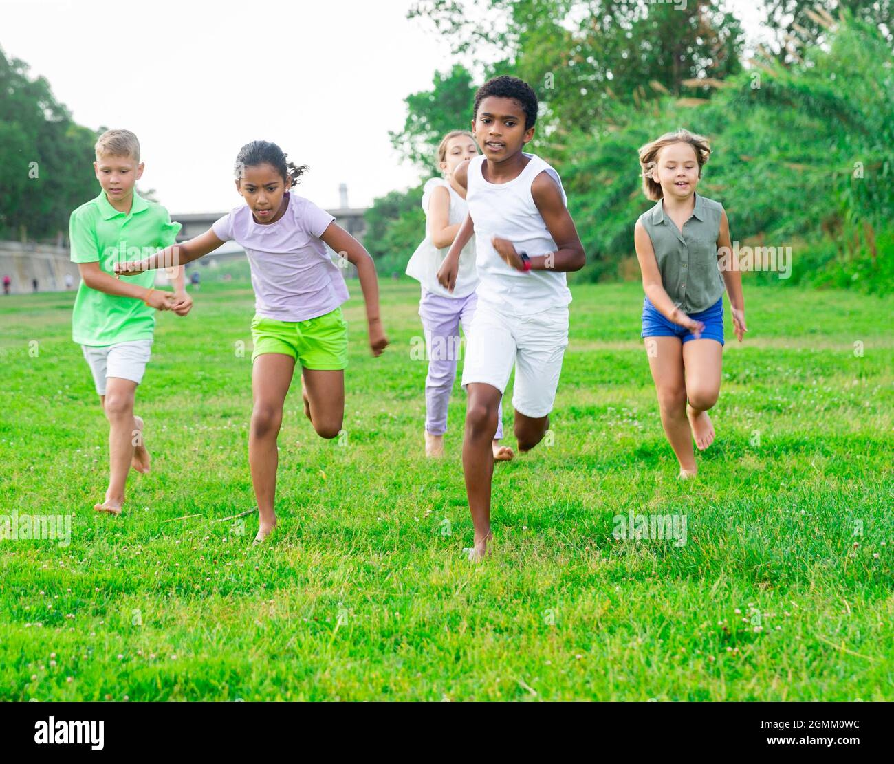 Five smiling kids running and laughing in park Stock Photo - Alamy