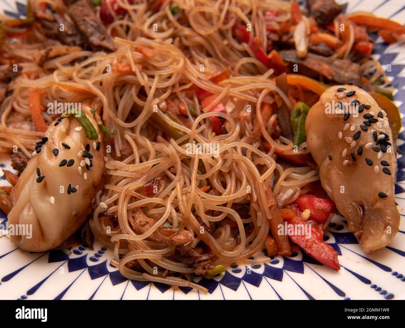 aerial view of a rice noodle wok dish with vegetables and two gyozas