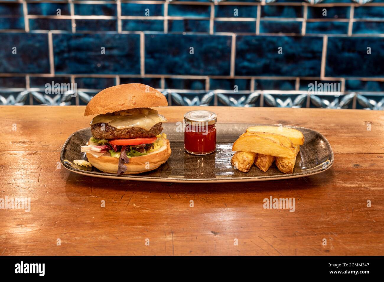 Beef burger with melted Emmental cheese, lettuce, tomato, onion. Tomato