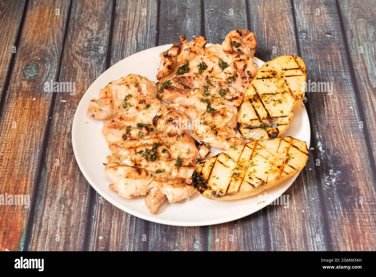 Provencal-style roasted boneless chicken fillets with halved potatoes Stock Photo