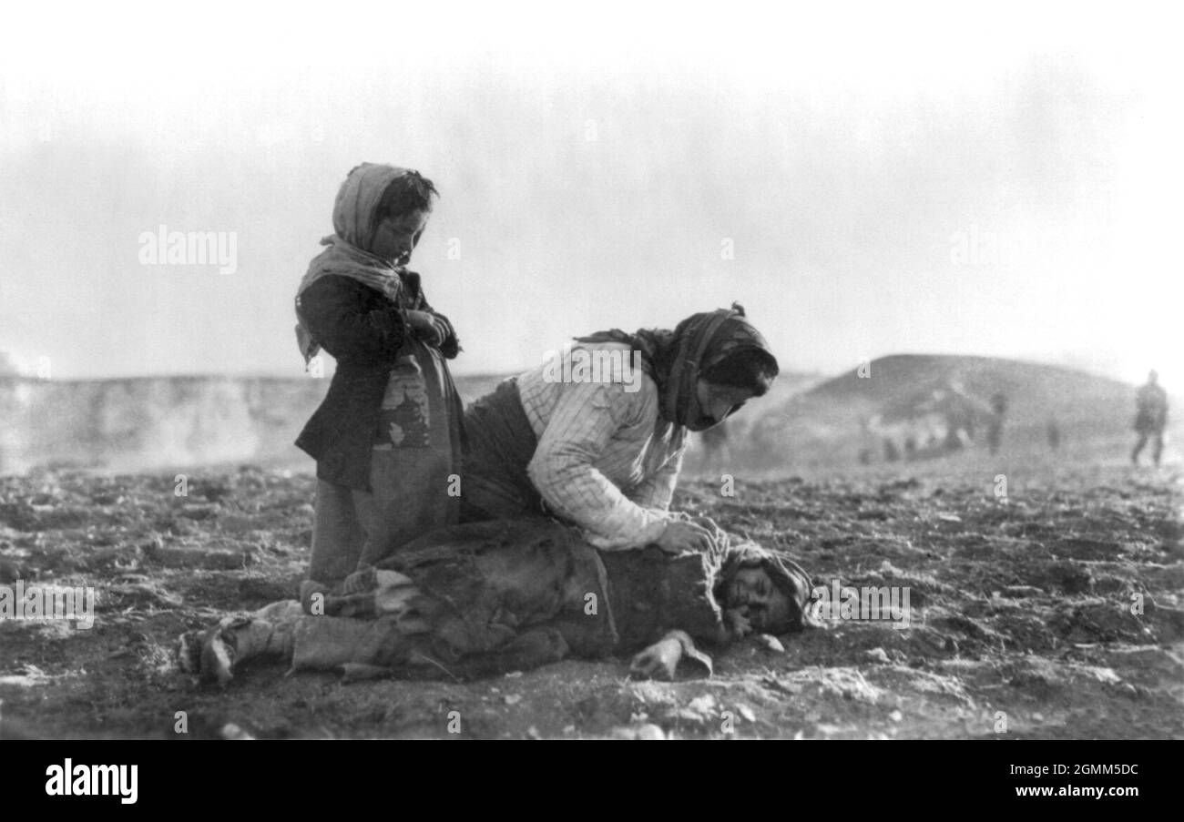 A woman crying over the body of a child during the Armenian genocide of 1915 Stock Photo
