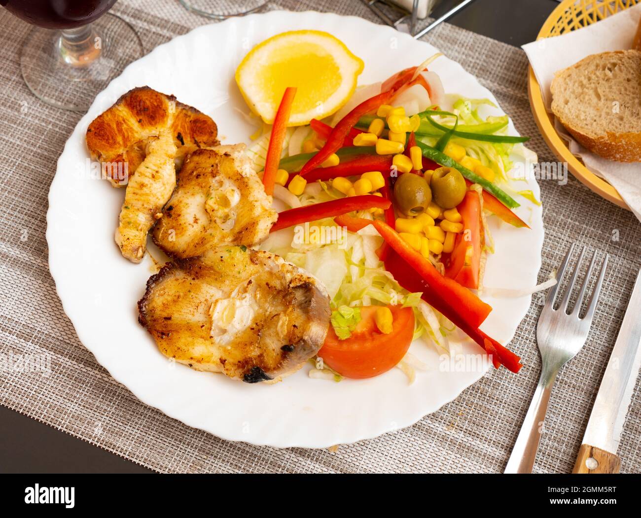 Oven baked hake with vegetable garnish Stock Photo