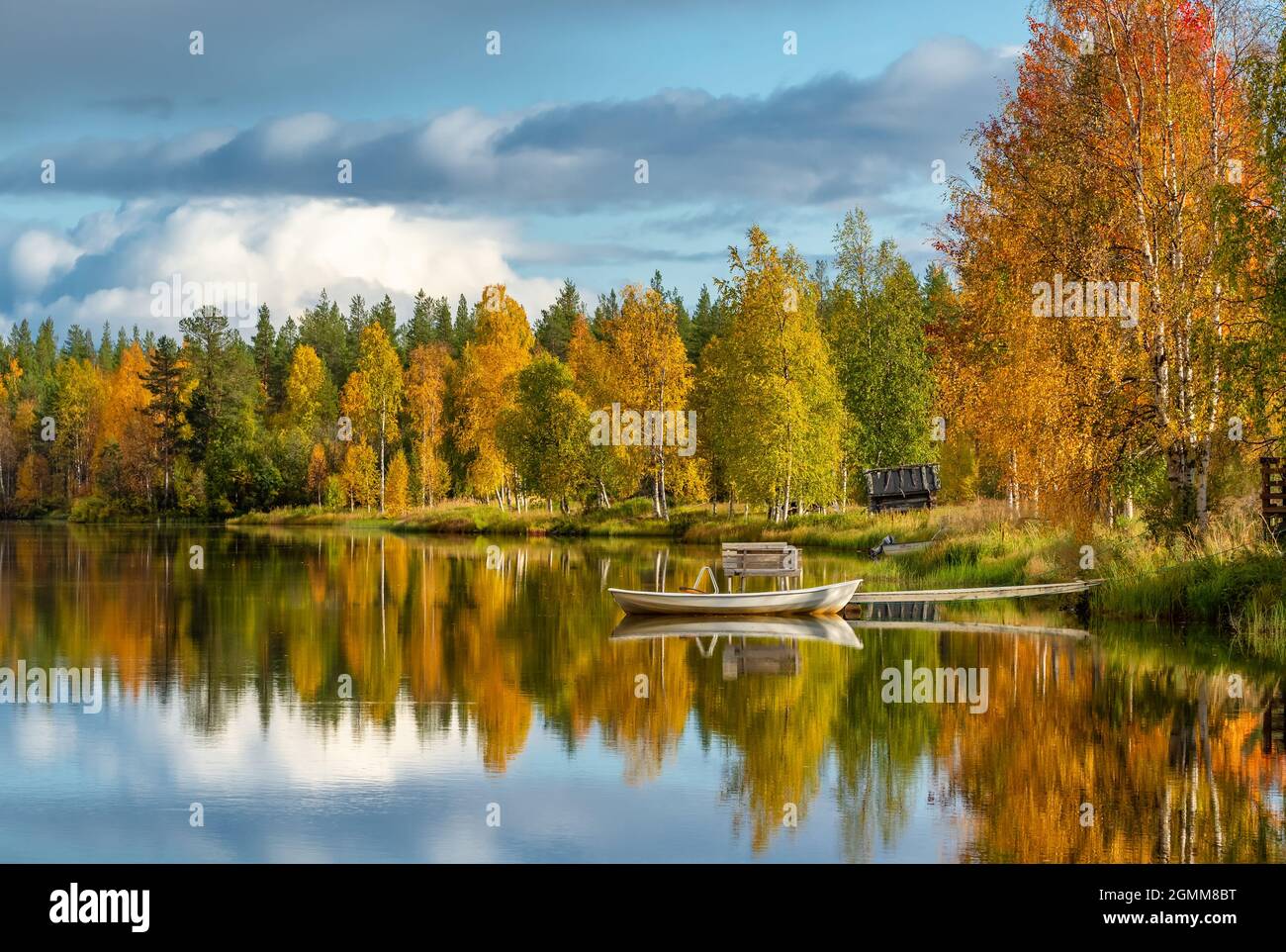 Calm water lake with a reflection of colorful autumn forest in Finland Stock Photo