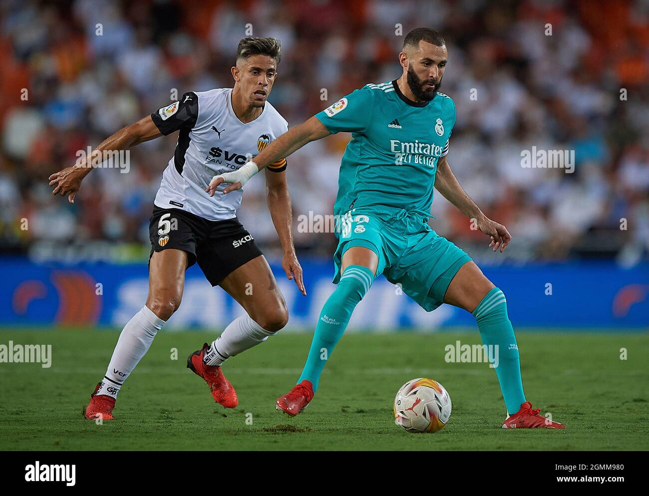 Valencia. 20th Sep, 2021. Real Madrid's Karim Benzema (R) vies with Valencia's Gabriel Paulista during a Spanish first division league football match between Valencia CF and Real Madrid in Valencia, Spain, on Sept. 19, 2021. Credit: Xinhua/Alamy Live News Stock Photo