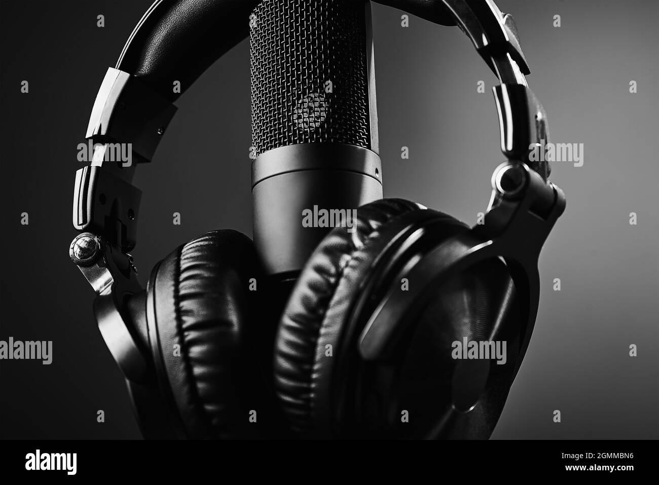 Studio microphone and headphones on the black background. Online podcast concept Stock Photo