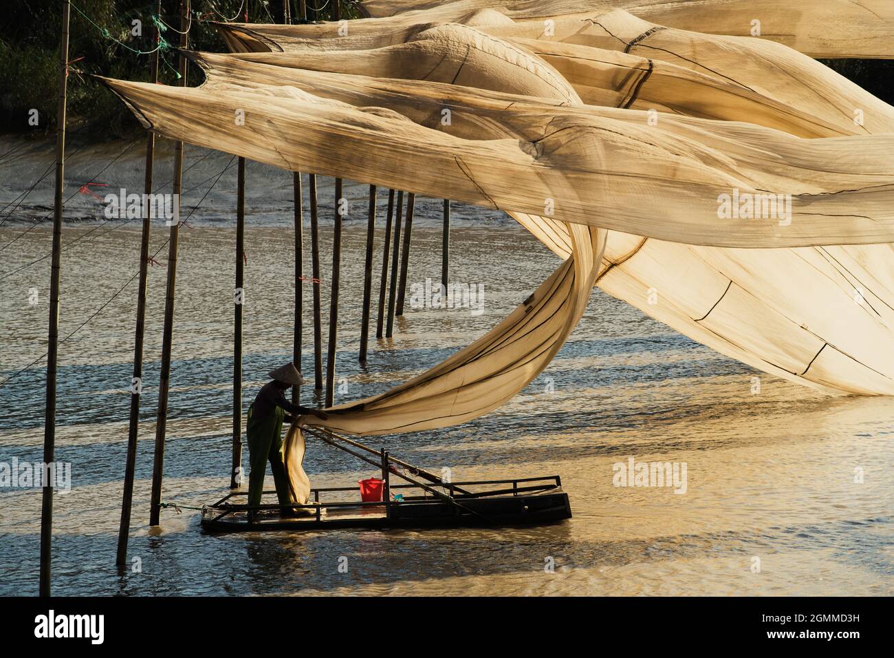XIAPU, CHINA – DEC 08, 2019: A fisherman hangs giant fishing nets