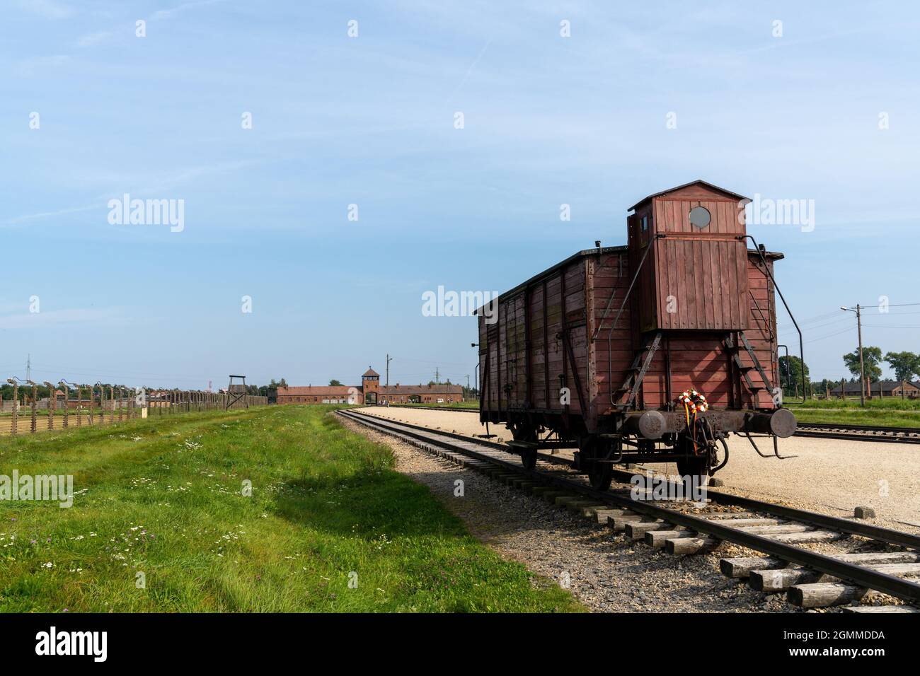 Auschwitz, Poland - 15 September, 2021: Auschwitz Concentration Camp in Poland with railroad tracks and a wooden carriage for transporting prisoners i Stock Photo