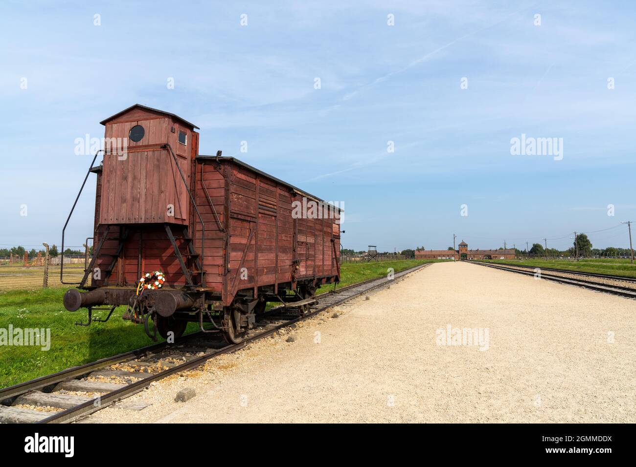Auschwitz, Poland - 15 September, 2021: Auschwitz Concentration Camp in Poland with railroad tracks and a wooden carriage for transporting prisoners i Stock Photo