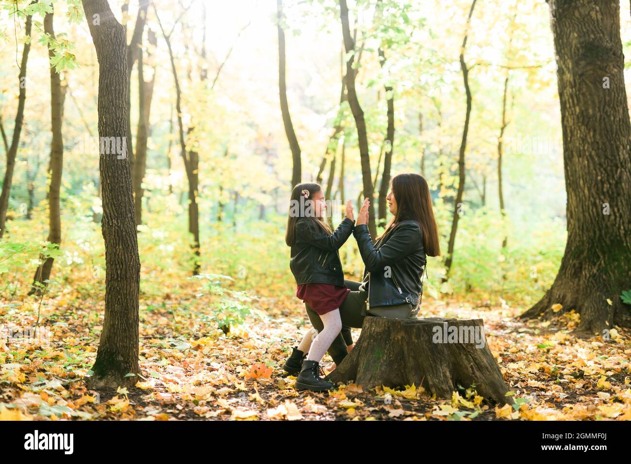 Mother and daughter spend time together in autumn yellow park. Season ...