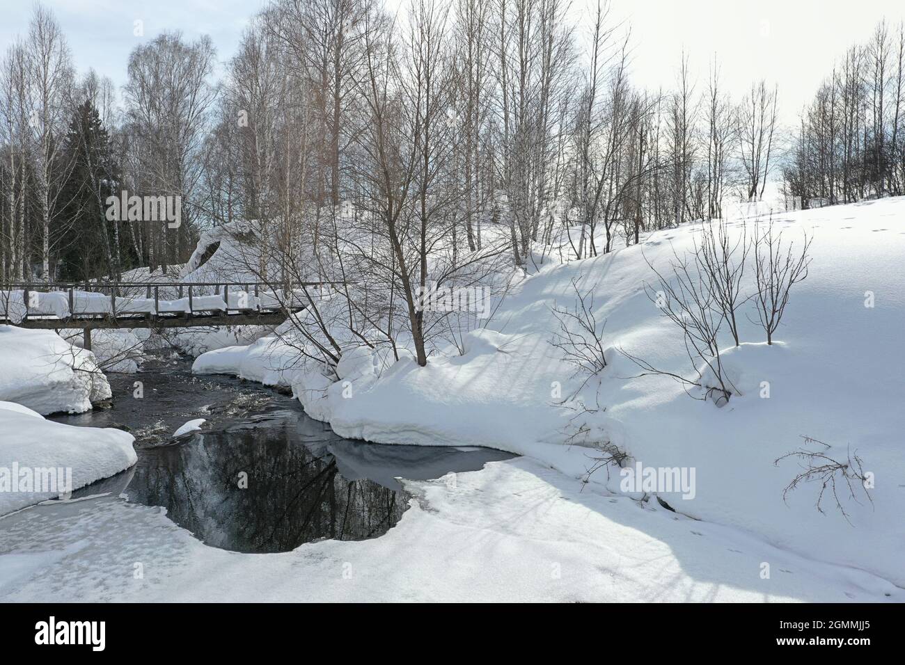 snowy wooden bridge over small river in Siberia Stock Photo