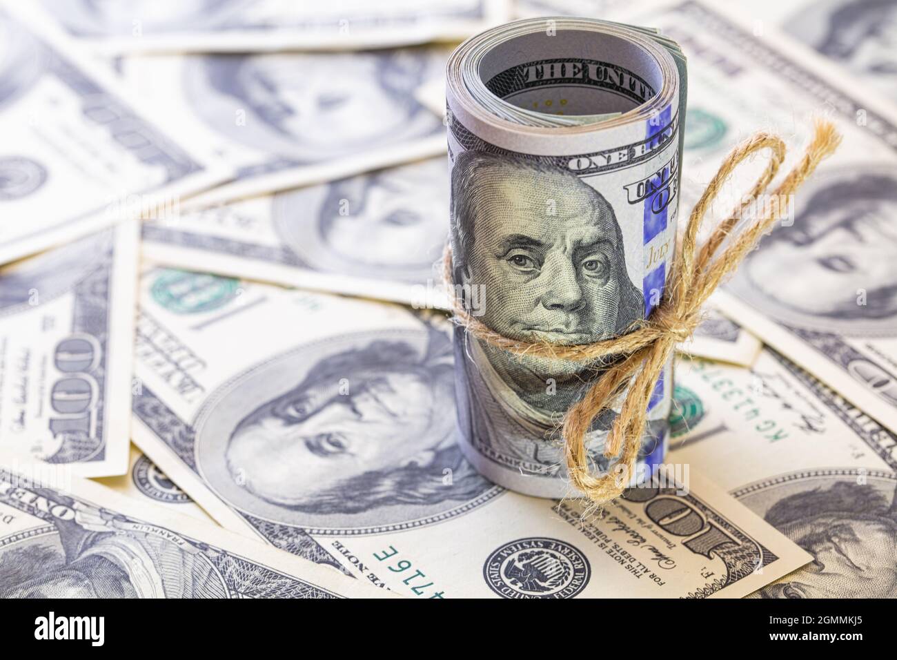 Roll of 100 dollar banknotes on dollars background Stock Photo - Alamy