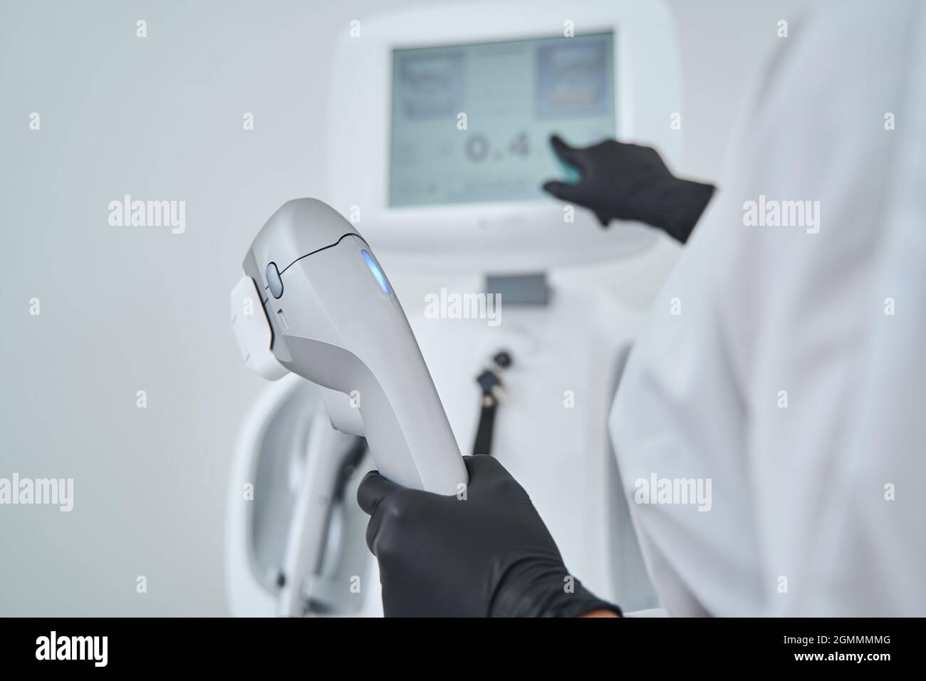 Professional dermatologist adjusting the equipment before a cosmetic